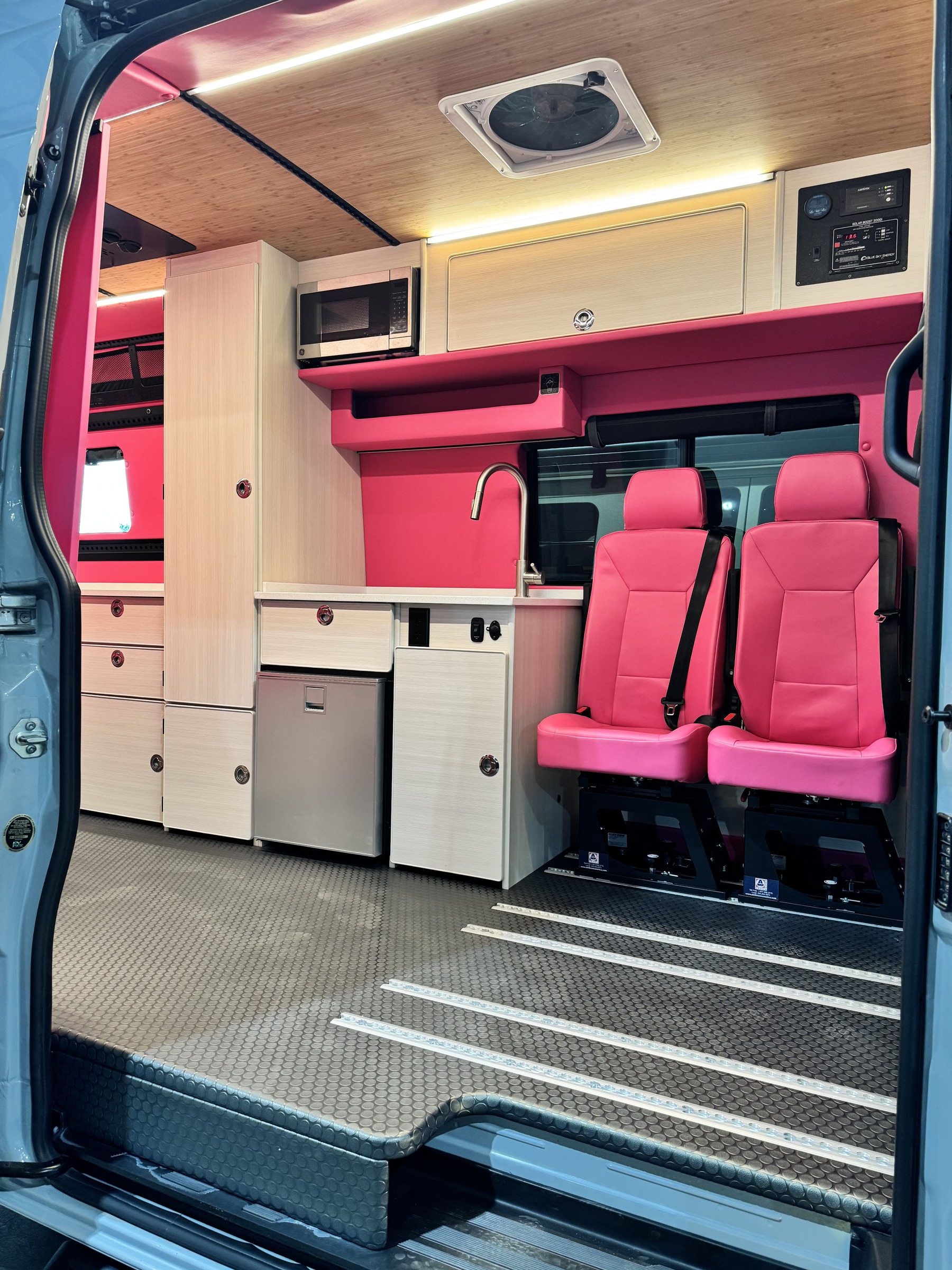 Dream Camp-Out overnight party seating and kitchen inside the pink van